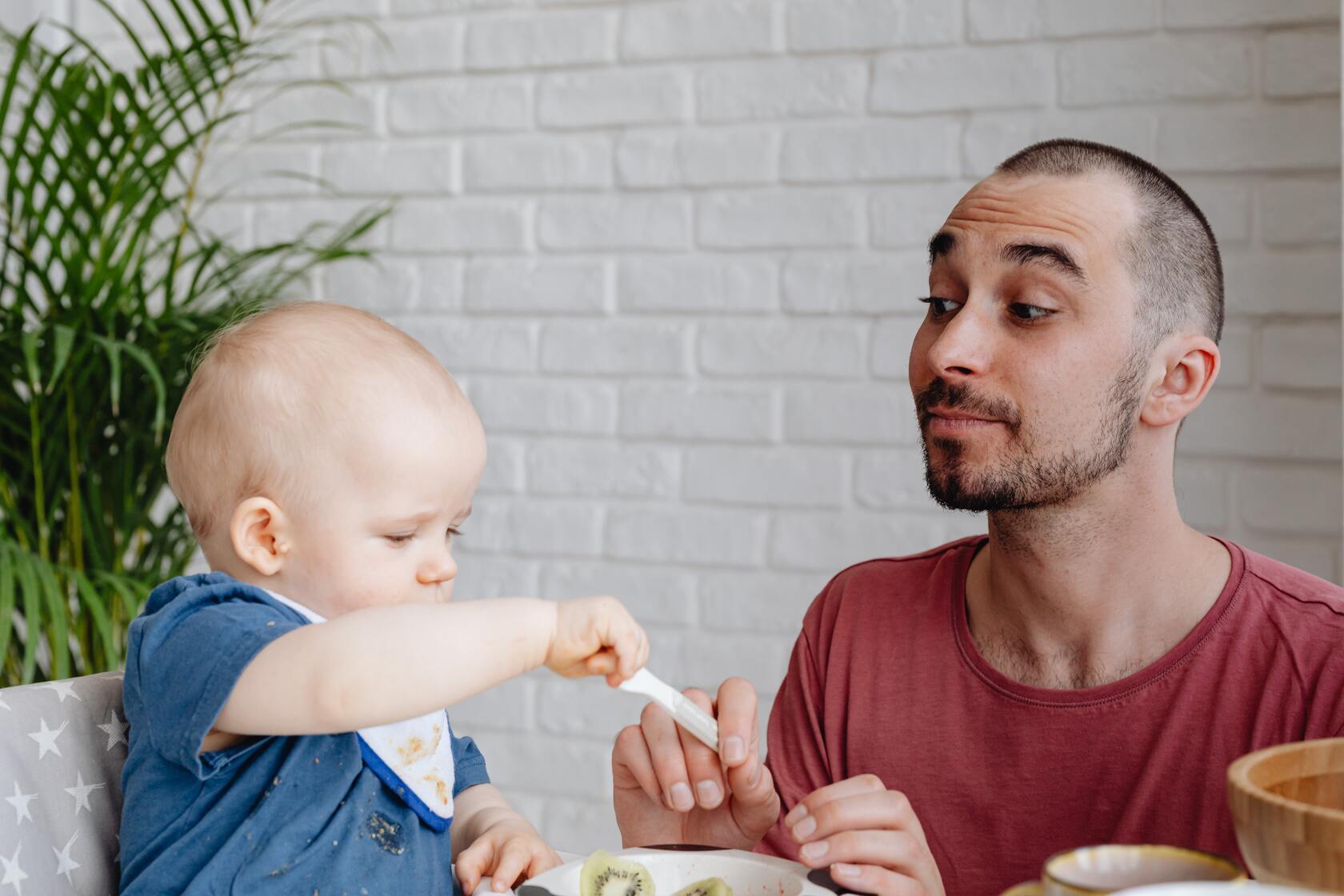 Dad feeding baby with spoon